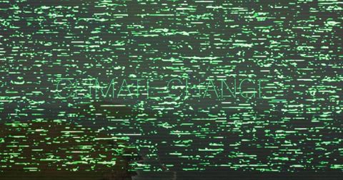 Flashing green glitch screen revealing faint female giant text with horizontal scanline noise