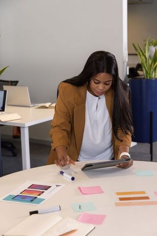 African american professional reviewing tablet and color mockups, planning design workflow