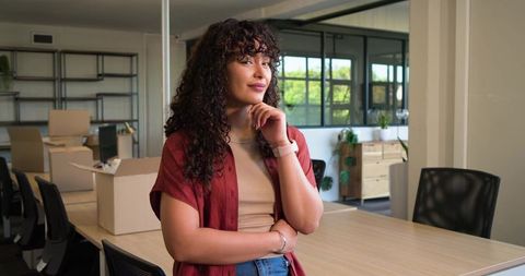 African american woman standing confidently in sunlit modern office during startup move-in