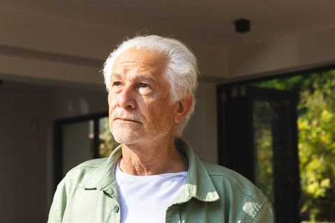 Contemplative Senior Man Enjoying Natural Light in Cozy Home