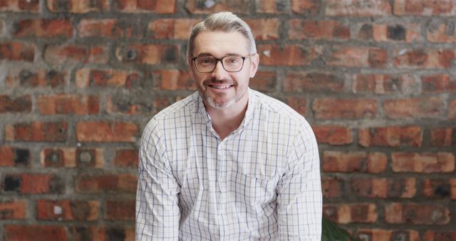 Confident Businessman with Glasses Smiling Against Brick Wall - Download Free Stock Images Pikwizard.com