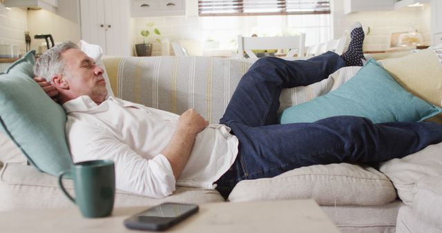 Happy caucasian man lying on sofa in living room, sleeping - Download Free Stock Photos Pikwizard.com