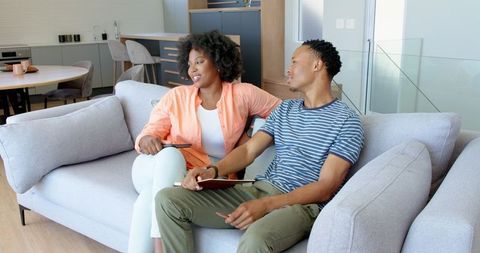 Happy Couple Relaxing With Tablet in Modern Living Room