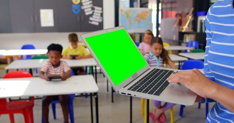 Teacher Using Laptop with Children Studying in Classroom - Download Free Stock Images Pikwizard.com