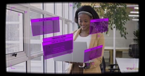 Standing professional holding laptop with augmented reality cybersecurity dashboards