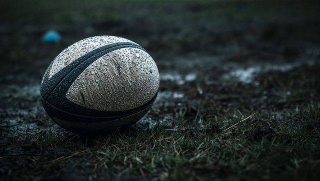 Rugby Ball on Rainy Field Showcasing Rugged Outdoor Sports Spirit