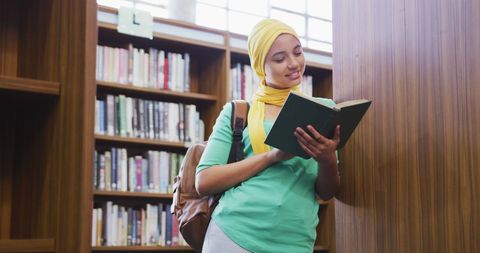 Teenage Girl in Library Focused on Book - Download Free Stock Images Pikwizard.com