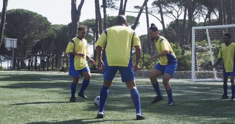 Soccer Players in Yellow Jerseys Practicing Teamwork