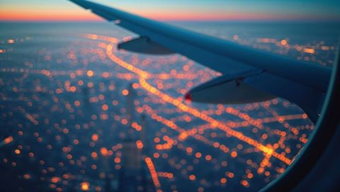 Airplane View at Twilight Over Glowing Urban Grid