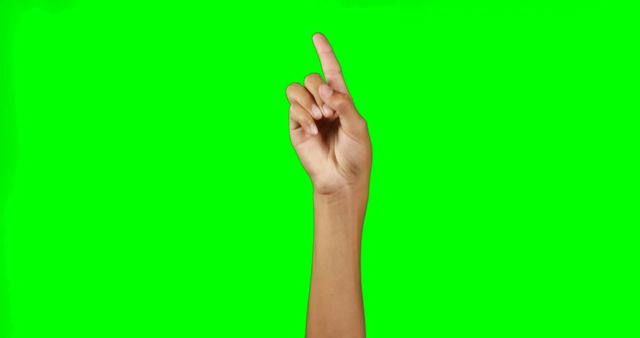 This depicts a human hand pointing upwards with the index finger extended against a green screen background. Ideal for use in educational videos, digital presentations, and visual effects work where the green background can be easily replaced.