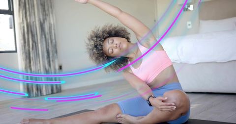 Woman stretching on home mat wearing wrist tracker with neon motion accents for yoga