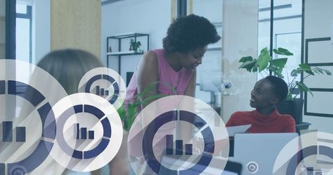Diverse women collaborating with business analytics in modern office