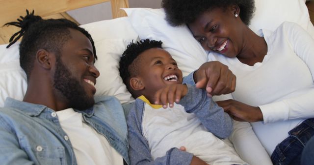 Happy African American Family Enjoying Time Together on Bed - Download Free Stock Images Pikwizard.com