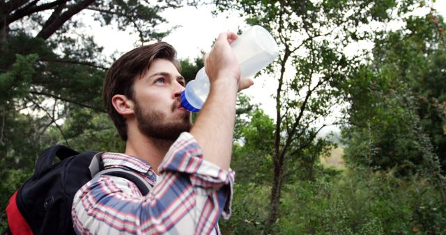 Young Man Hydrating While Hiking in Forest - Download Free Stock Images Pikwizard.com