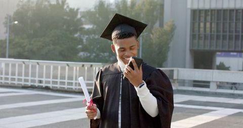 Young Graduate Celebrating with Diploma and Smartphone on Campus Plaza