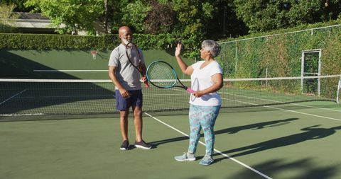 Senior Couple High-Fiving on Tennis Court Promoting Active Lifestyle - Download Free Stock Images Pikwizard.com