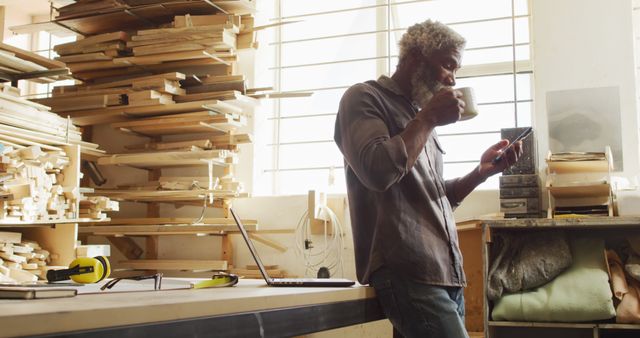 Carpenter Enjoying Coffee Break in Workshop While Using Smartphone - Download Free Stock Images Pikwizard.com