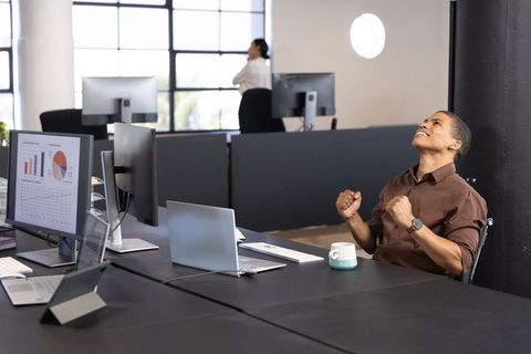 Excited Businessman Celebrating in Modern Office Environment