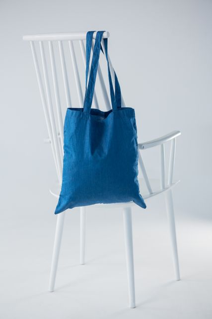 Blue bag hanging on a white chair - Download Free Stock Photos Pikwizard.com