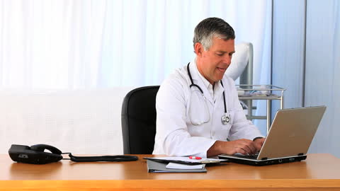 Doctor Working on Laptop in Modern Office