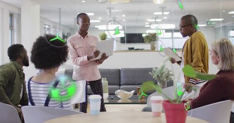 Diverse team collaborating in modern open-plan office with presenter using tablet and AR