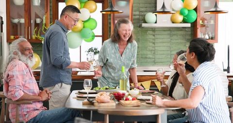 Joyful Senior Friends Celebrating at Lively Dinner Party