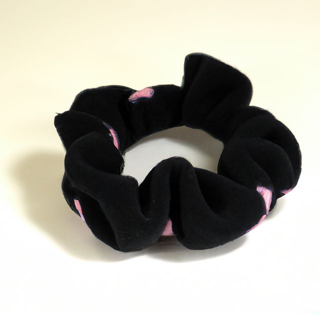 Image of close up of black and pink coloured scrunchie on white background. Hair and beauty, decoration concept.