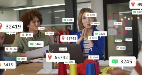 Fashion design team collaborating with social engagement notifications in modern studio