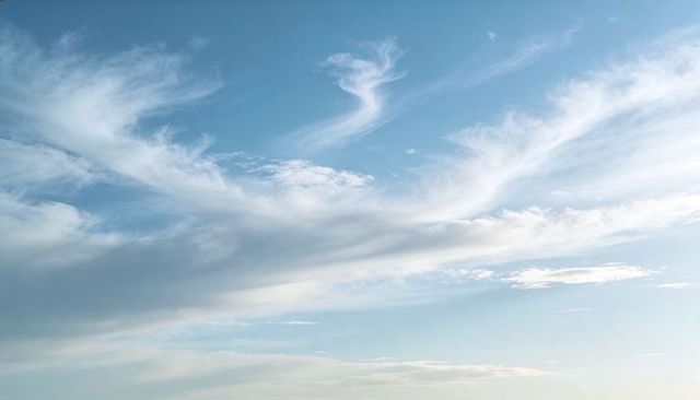 Sunlit Blue Sky with Wispy Cirrus Clouds, Soft Horizon Glow and Airy Minimal Cloudscape