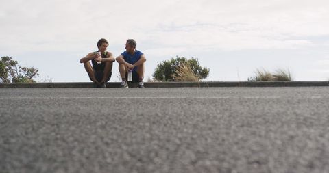 Senior Father and Adult Son Resting After Outdoor Run