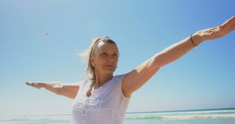 Active Senior Woman Practicing Yoga with Outstretched Arms on Sandy Beach - Download Free Stock Images Pikwizard.com