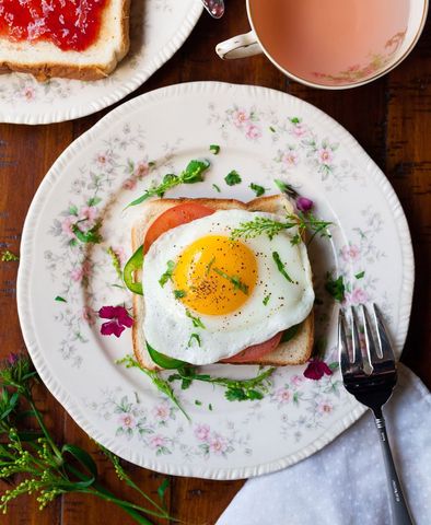Sunny-Side Egg Topping Toast on Vintage Floral Plate with Tea for Cozy Morning Brunch