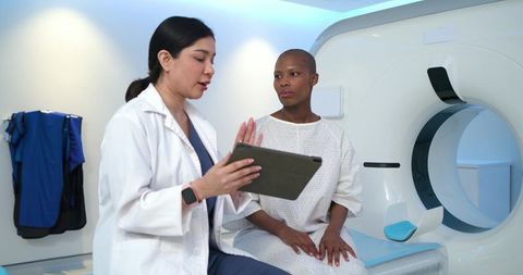 Asian doctor consulting african american patient before ct scan in radiology suite