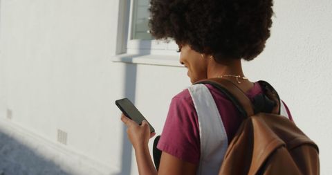 Young woman enjoying day while using smartphone