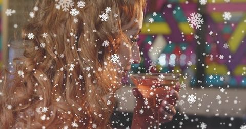 Sipping cocktail in neon lounge with snowflake overlay, blonde woman enjoying winter night