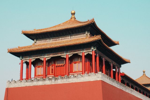 This traditional structure showcases iconic Chinese architecture with red walls and a gold roof. Great for use in travel brochures, educational materials on world history, cultural posters, or articles about historical landmarks in China, particularly Beijing. This conveys cultural heritage and traditional design.
