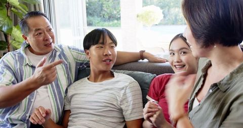 Family Laughing Together at Home on the Sofa