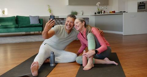 Senior Couple Enjoying Yoga and Taking Selfie in Modern Home Setting