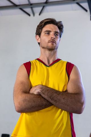 Confident Male Athlete in Yellow Sports Jersey in Gym