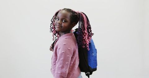 Young Girl with Backpack Posing Confidently in Studio