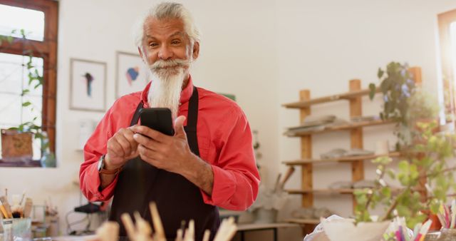 Senior Artist Checking Smartphone in Creative Studio - Download Free Stock Images Pikwizard.com