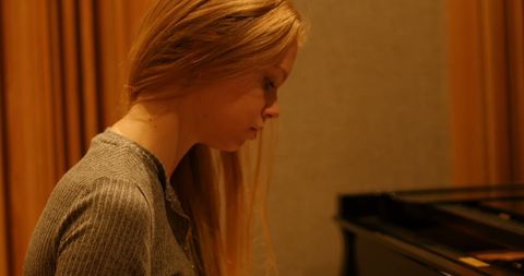 Focused Woman Playing Piano in Studio Setting