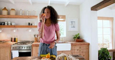 Woman Sniffing Orange in Rustic Farmhouse Kitchen