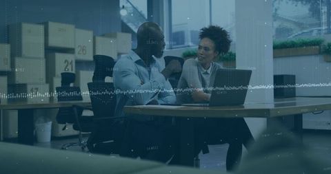 Office professionals analyzing data on laptop in modern workplace