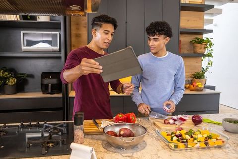 Friends Using Tablet for Cooking in Modern Kitchen