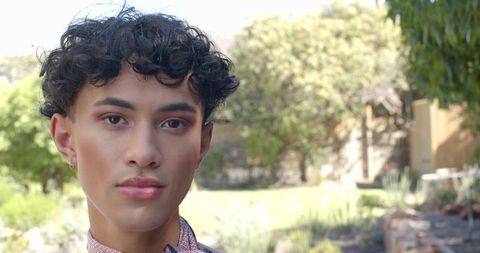 Confident Man in Garden Wearing Patterned Shirt and Silver Hoopa, Elegant Lifestyle