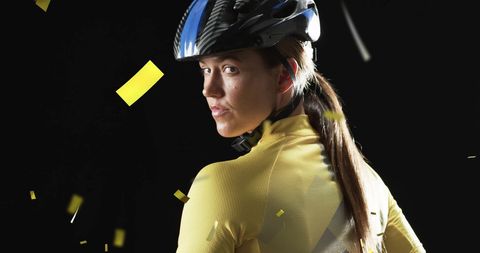 Caucasian female cyclist celebrating victory with confetti