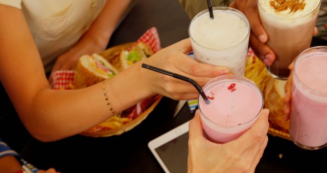 Friends Toasting with Milkshakes at Cafe Table with Snacks - Download Free Stock Images Pikwizard.com