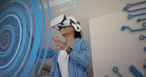 Smiling woman wearing vr headset interacting with blue hud overlays in modern workspace