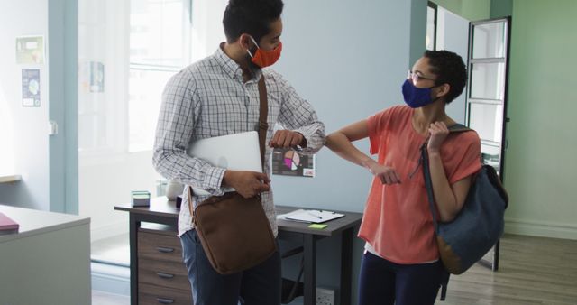 Colleagues Greeting with Elbow Bump in Office While Wearing Masks - Download Free Stock Images Pikwizard.com